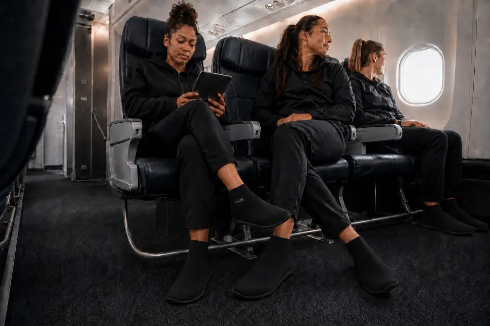 Deportistas en un avión con COOPS gris ceniza y negros.