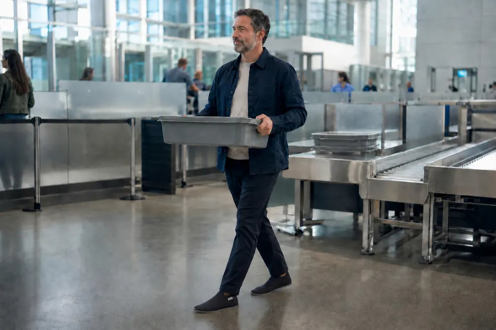 Traveler walking through airport security in black COOPS Low Tops.