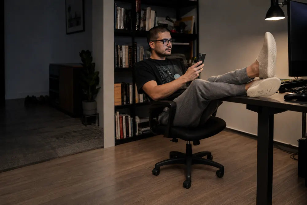 Jugador con los pies sobre el escritorio y COOPS Low Tops color arena.