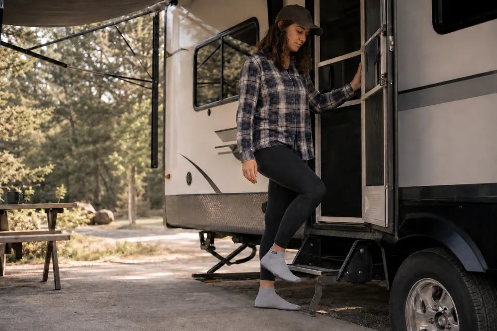 Traveler stepping out of an RV door in ash gray COOPS High Tops.