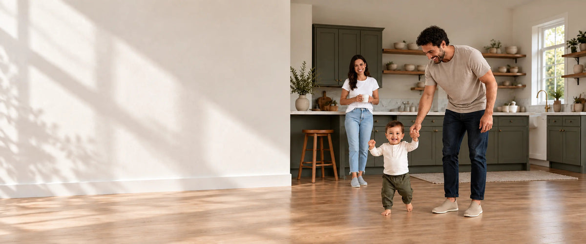 Parents en chaussures-chaussettes COOPS marchant avec leur tout-petit dans une cuisine ensoleillée