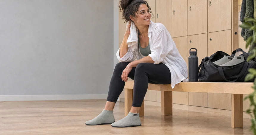 Athlete changing into COOPS post-workout recovery shoes