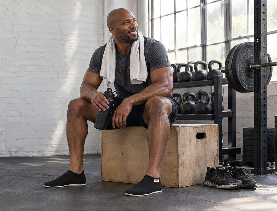 Athlete resting on a plyo box after training in Black COOPS Low Top sock shoes