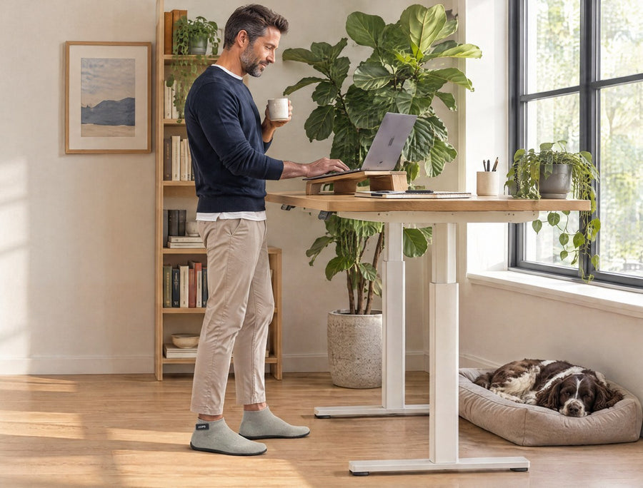 Woman with a coffee at a standing desk in her home office, wearing Sand COOPS Low Top sock shoes