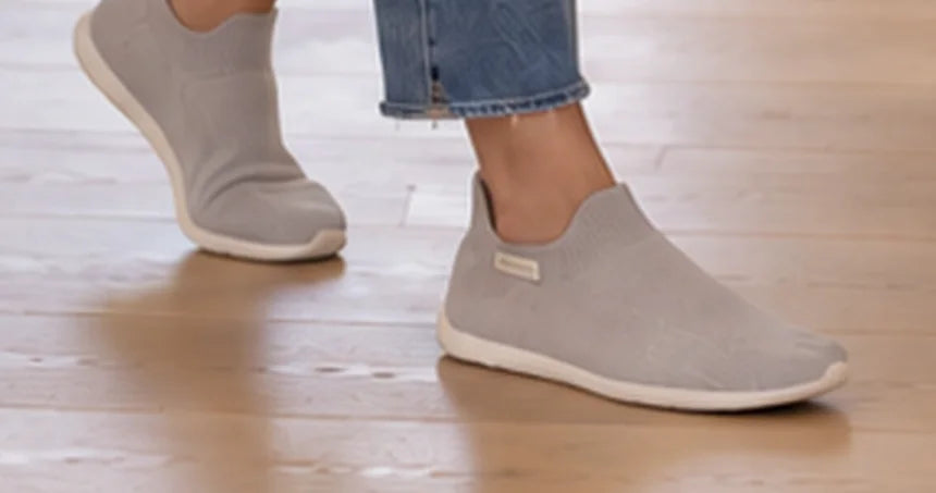 Madre o padre con zapatos calcetín COOPS durante una mañana ajetreada en casa