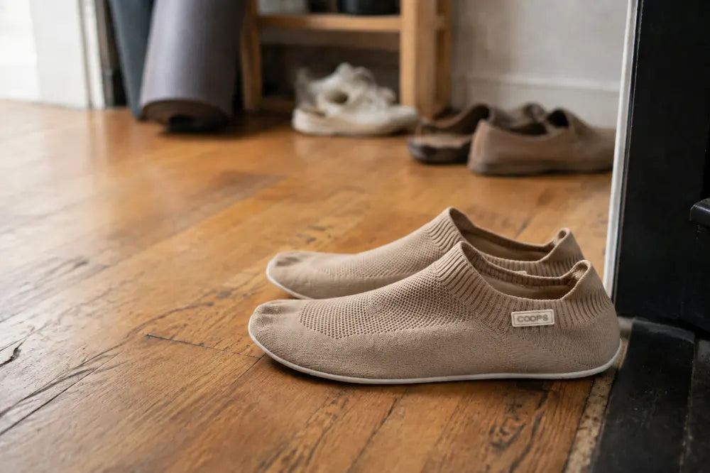Sand COOPS Low Tops placed beside a studio door.
