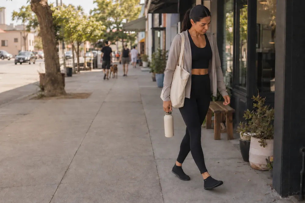 Woman walking a street after class in black COOPS High Tops.