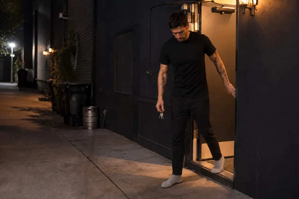 Hospitality worker leaving through a back door in sand COOPS Low Tops.