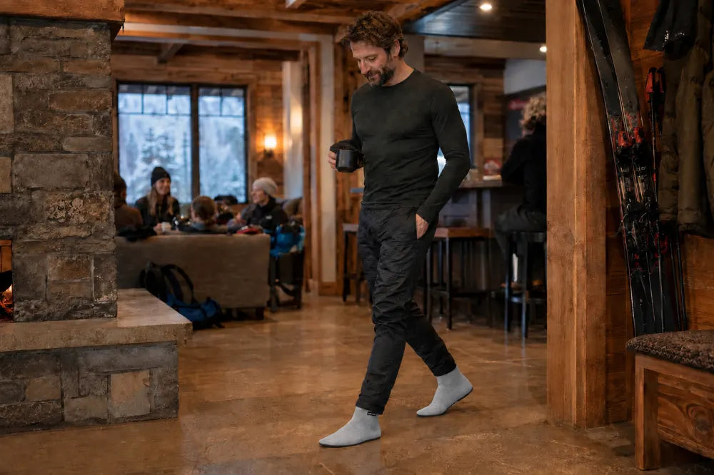 Skier walking through a lodge in ash gray COOPS High Tops.