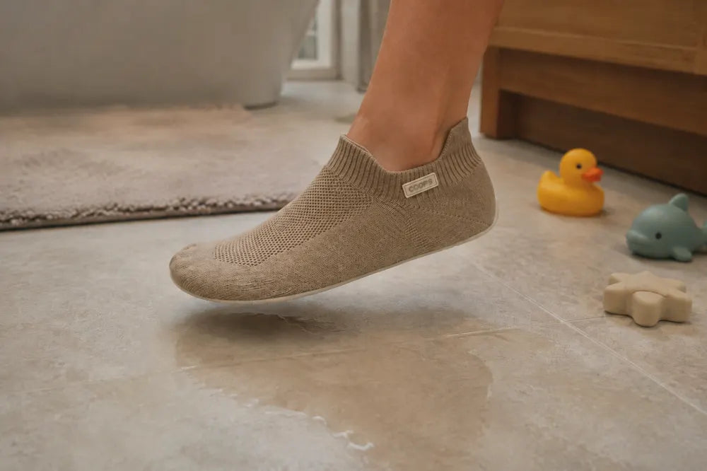 Sand COOPS Low Top on a wet bathroom floor beside bath toys.
