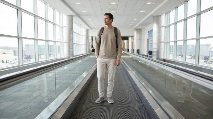 Traveller on an airport moving walkway wearing COOPS sock shoes