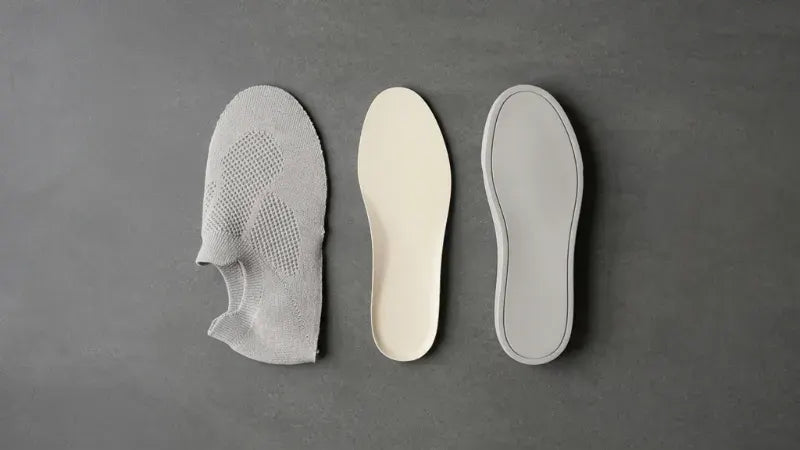 COOPS knit uppers and insoles laid out on a grey surface